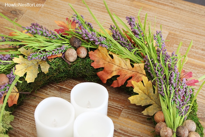 Wreath with little purple flowers, leaves, and sprigs of greenery.