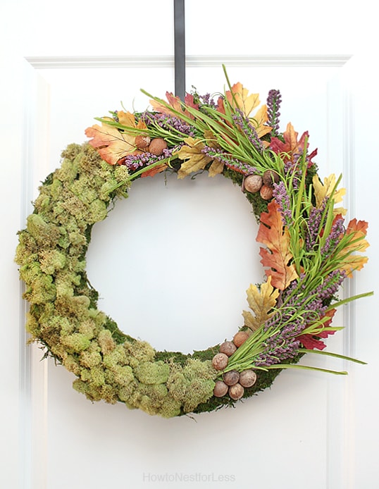 The moss centrepiece and wreath hanging on a door.