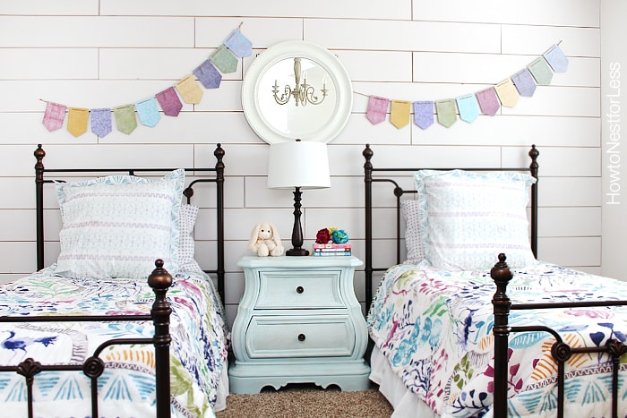 White plank wall girls bedroom with a banner on the wall.