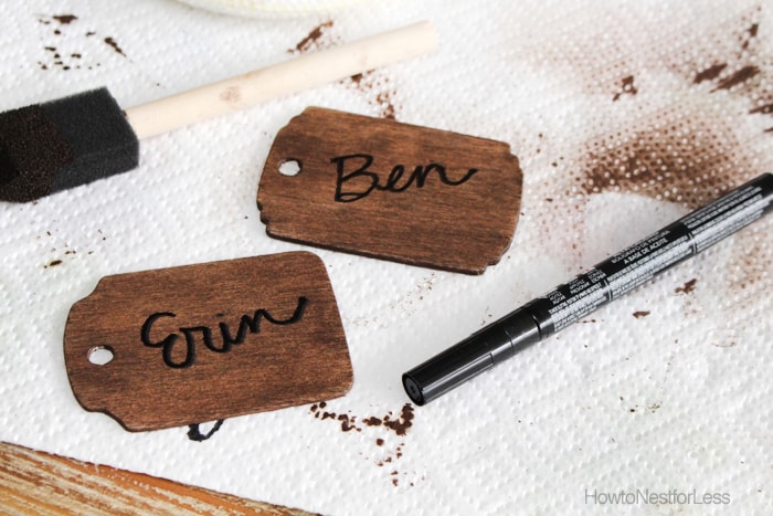 Writing the names of your guests on the wooden stained tags.