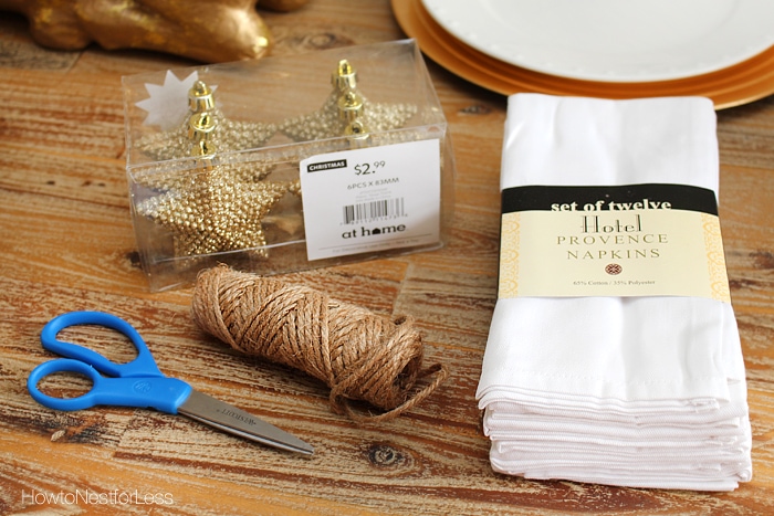 Sparkly stars in a package, scissors, twine, and napkins on the table.
