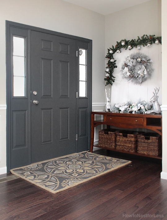 Entry foyer painted front door with a rug in front of it.