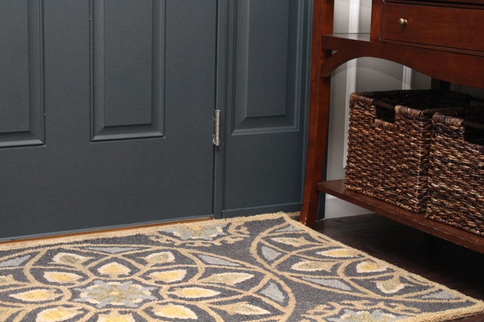 A close up of the rug and painted gray front door.