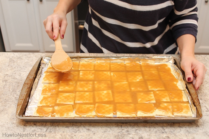 Spreading the toffee evenly over the saltines.
