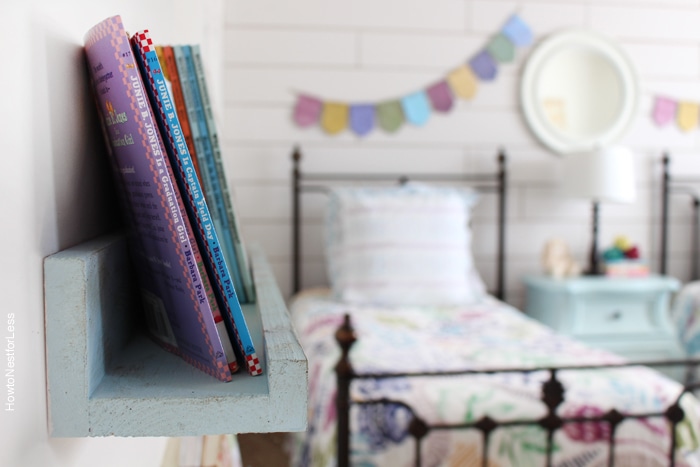 Looking at the shelf from the side with a bed in the background.