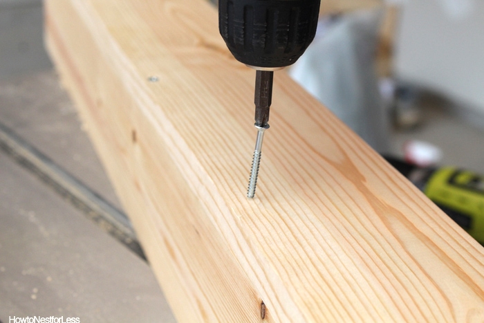 Using an electric screwdriver to insert a screw.