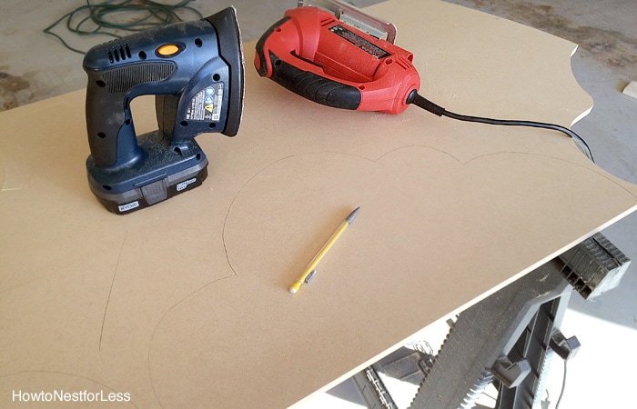 Power tools on wooden board to cut out cloud shapes.