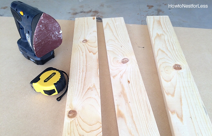 The wood, sander and tape measure on ground ready to cut.