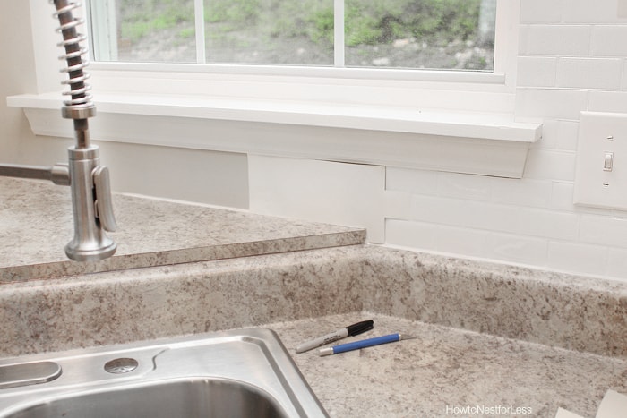 Kitchen sink with pen and exacto knife beside it.