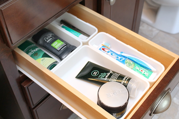 Deodorant, toothbrush and hair products in drawer.