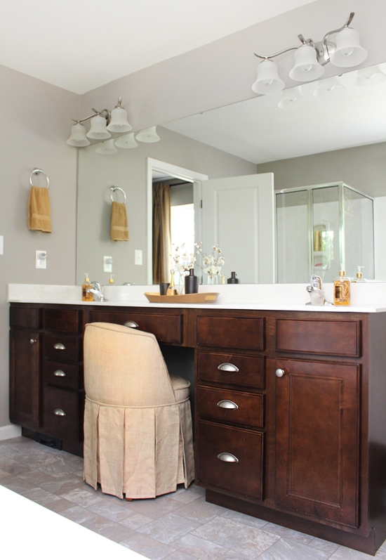 The master bathroom with a large mirror and light fixture above it.