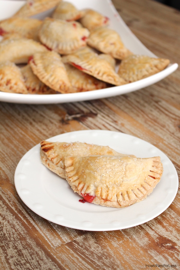 The baked mini pies on a white plate on the counter.