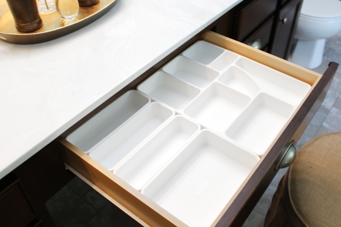 Fitting the plastic organizers in the drawer of the vanity.