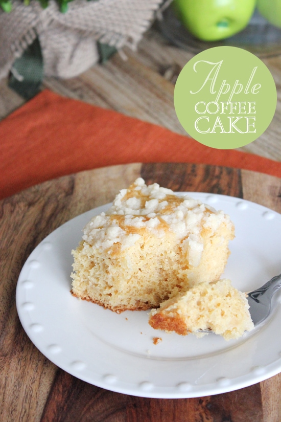 Apple coffee cake on a white plate with a bite taken out of it.