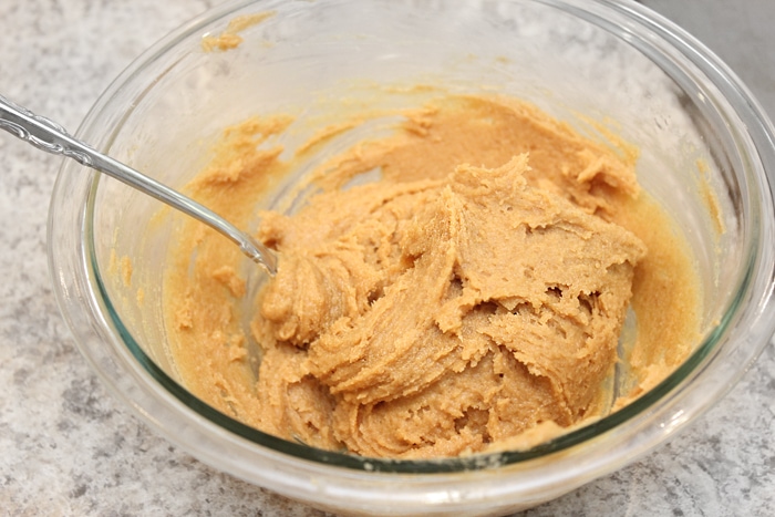 Mixing the ingredients together in a glass mixing bowl.