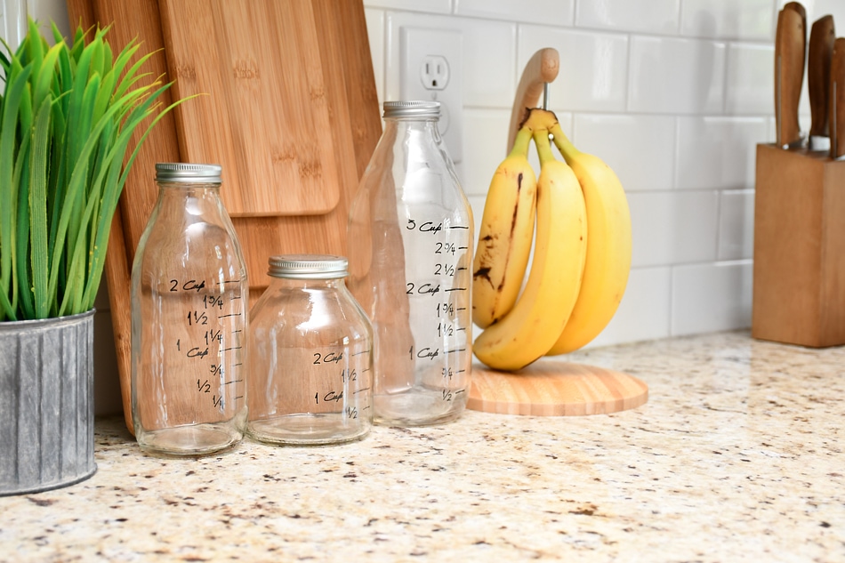 Close up of the white subway tile plus bananas and knives on the counter.