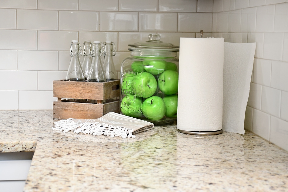 Apples in a glass jar on the counter in the kitchen.