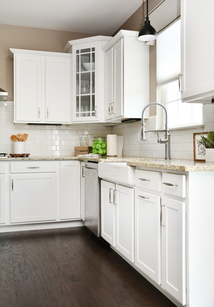 White corner kitchen cabinet with a glass door.