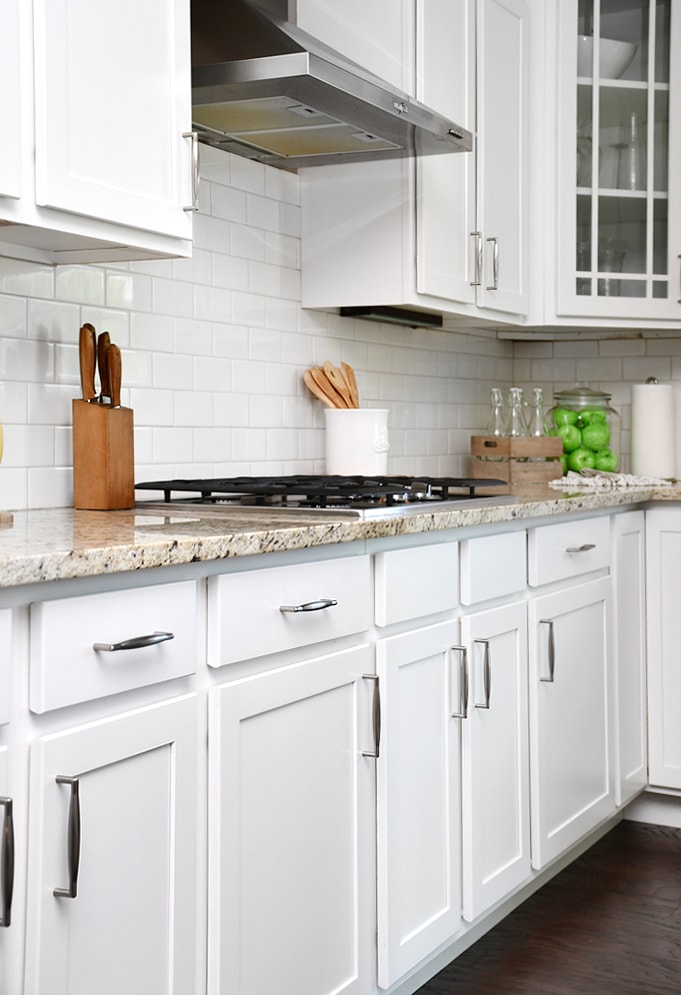 White lower kitchen cabinets with stainless steel pulls.