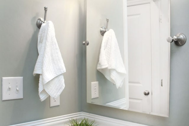 closeup of towel hanging on wall with mirror and wall painted Sherwin Williams Oyster Bay