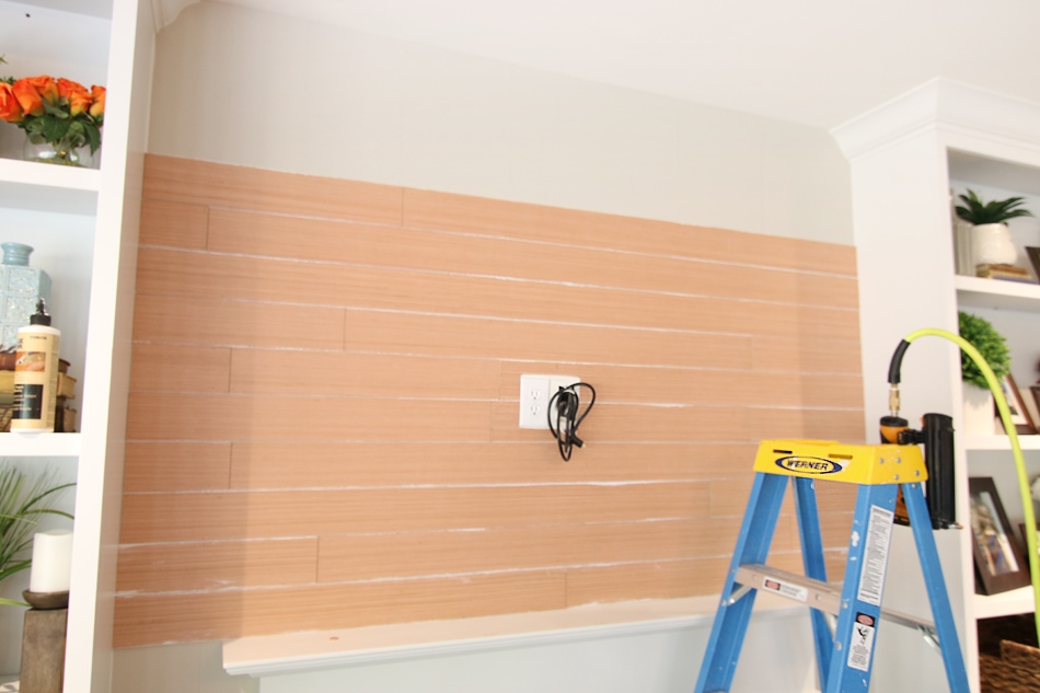 A step ladder in front of the boards on the wall.