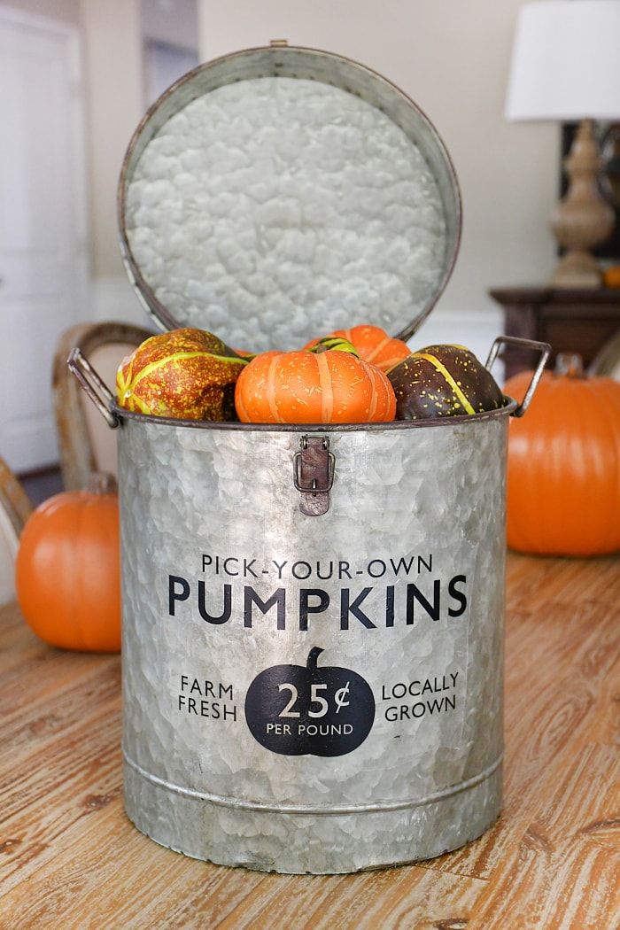 Galvanized bucket filled with pumpkins.