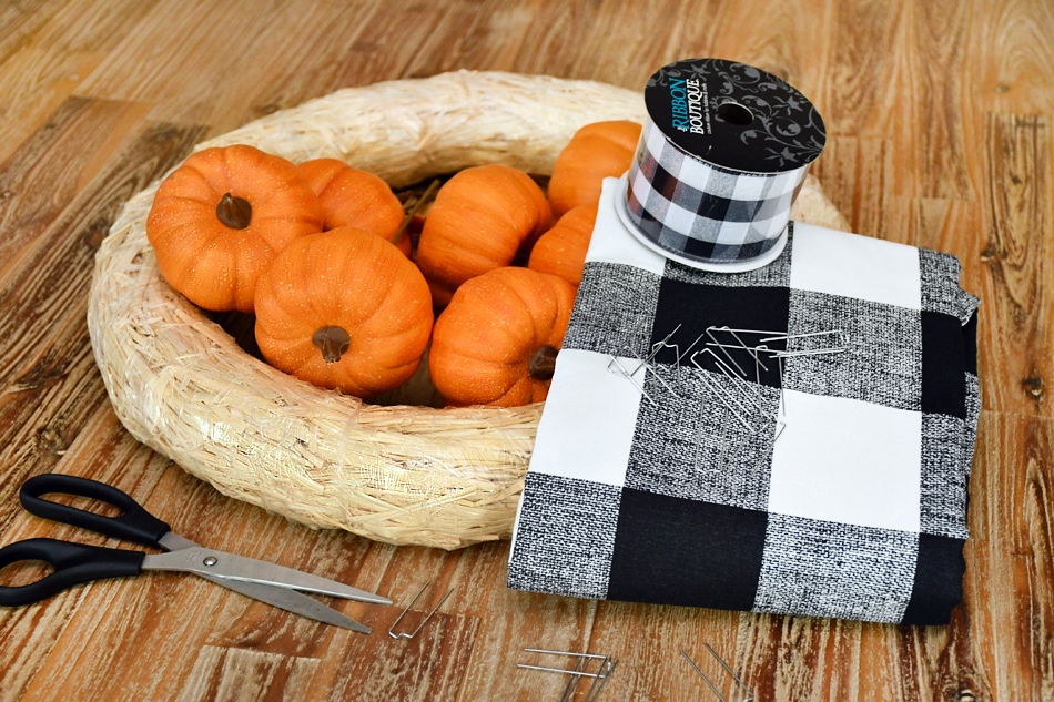 On the counter, the pumpkins, wreath, buffalo material, ribbon and scissors.