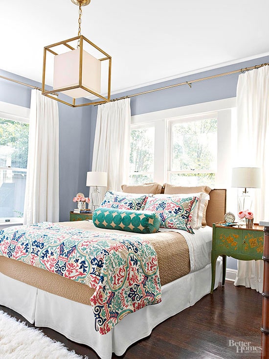 Indigo walls and multicoloured bedding in master bedroom.