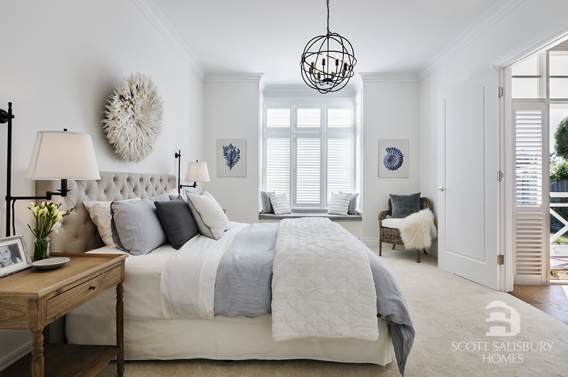 Neutral toned bedroom with rustic chandelier.