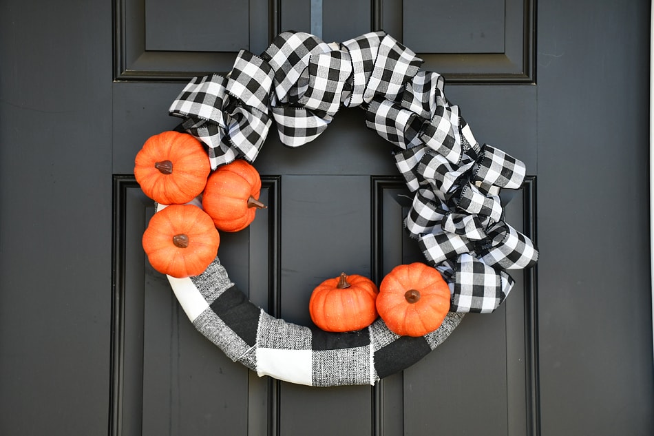 Little orange pumpkins on a checkered wreath.