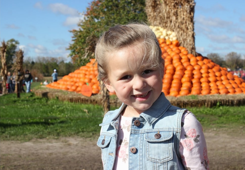 Girl smiling at the pumpkin patch.