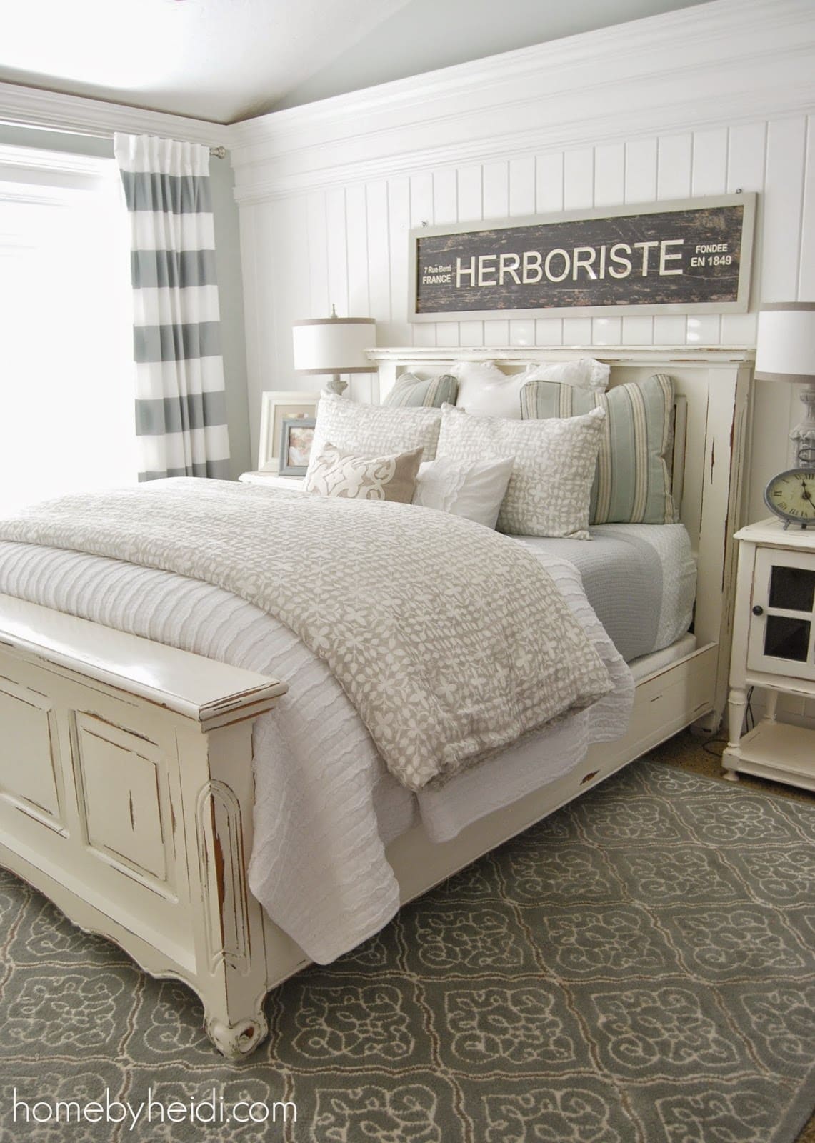 White distressed bed frame and white bedding in bedroom.