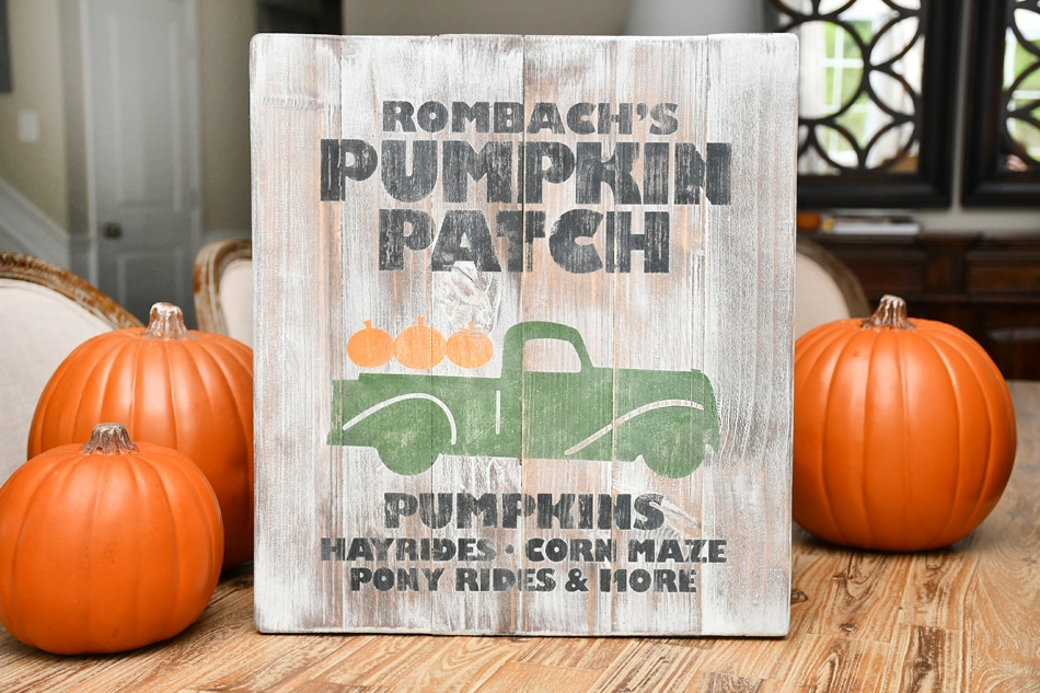 Rombachs pumpkin farm sign standing up with pumpkins behind it.