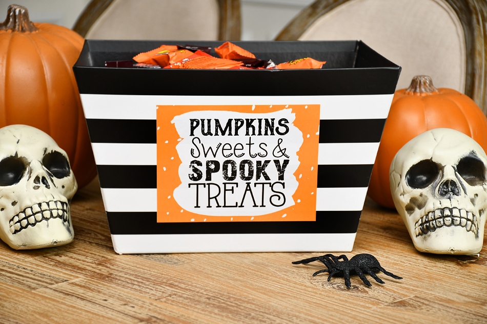 Halloween candy in the bowl on the decorated table.