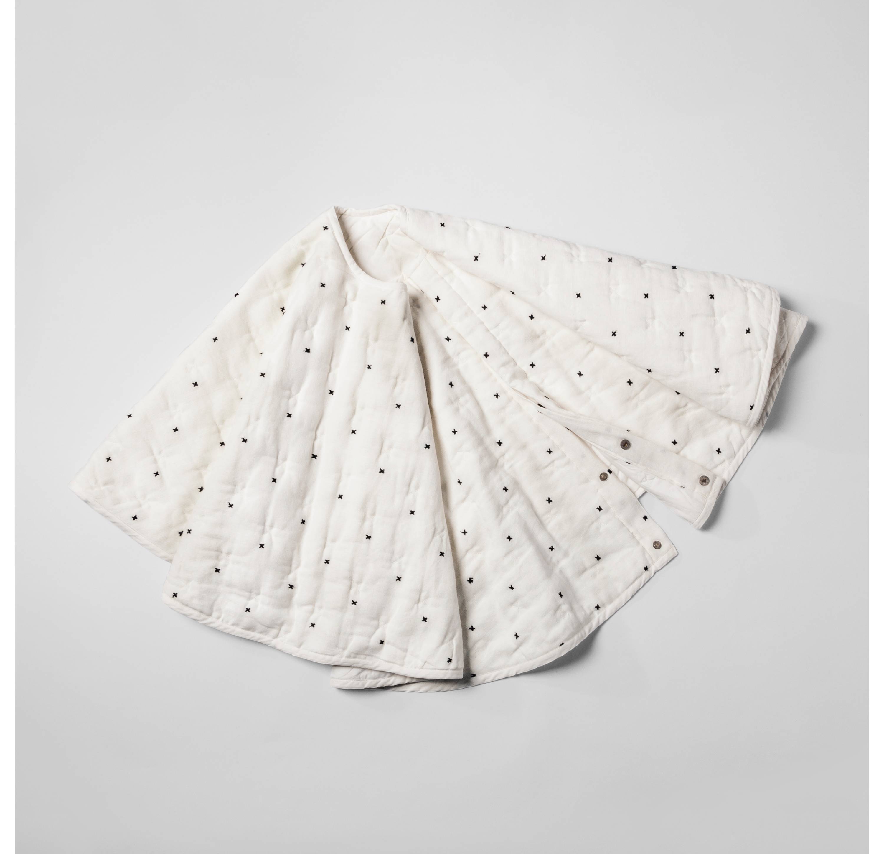 A white tree skirt with black dots on it.