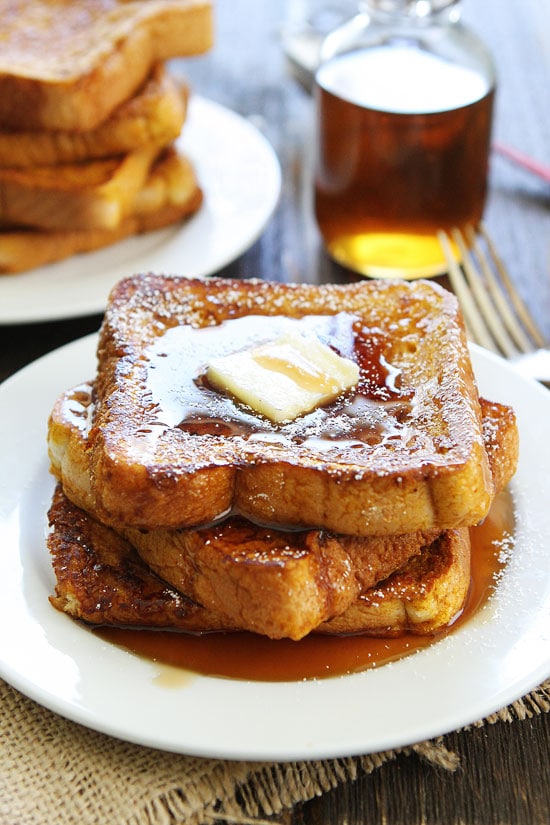 Stacked pumpkin French toast with syrup and butter on top.