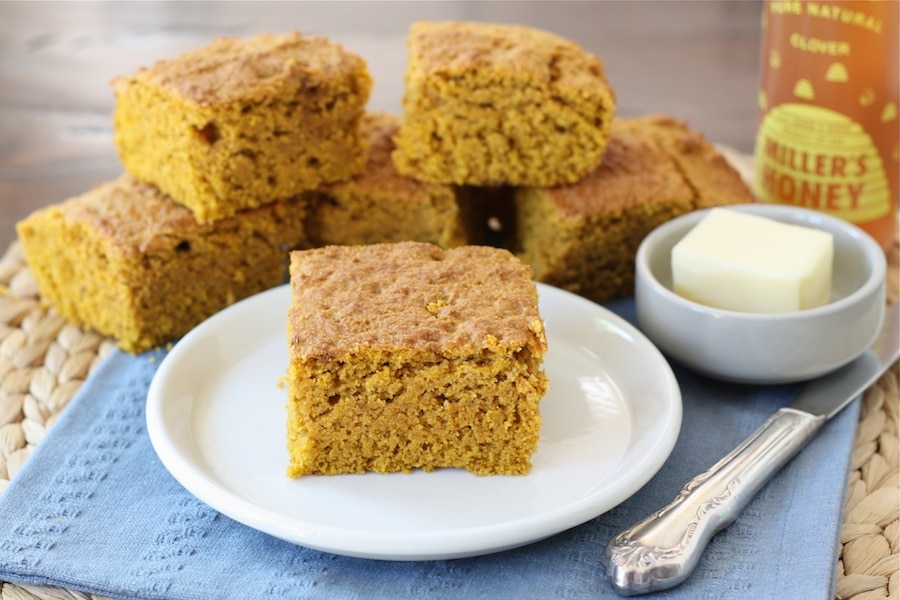 Cornbread made out of pumpkin sliced in squared on a plate.