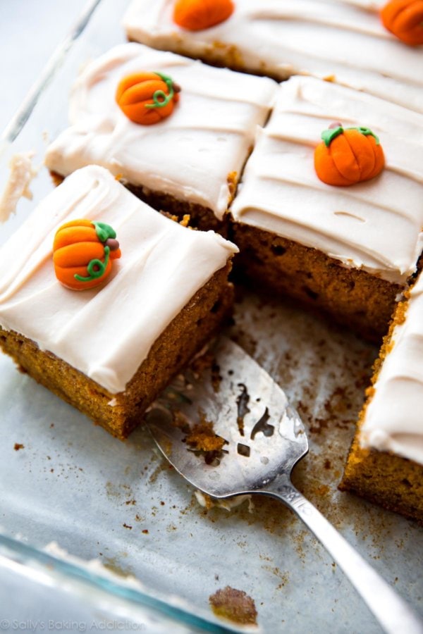 Pumpkin cake with cream cheese icing and mini pumpkins on top.