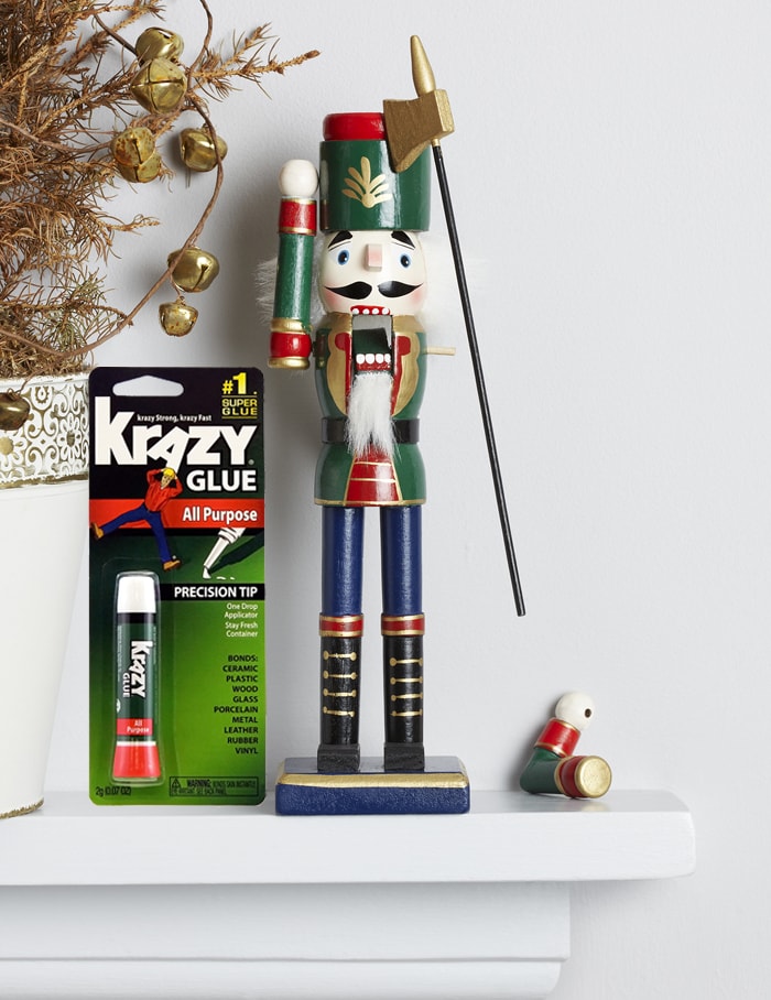 A broken Christmas toy and Krazy Glue beside it in the package.
