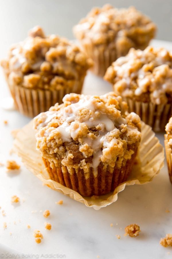 Pumpkin muffins on the counter with some icing on top.