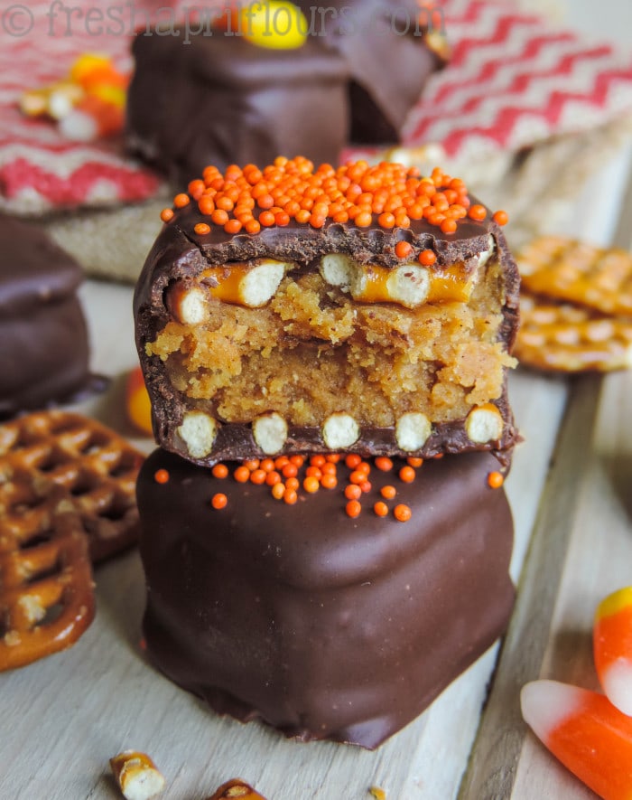 Pumpkin peanut butter pretzel truffles with one cut in half.