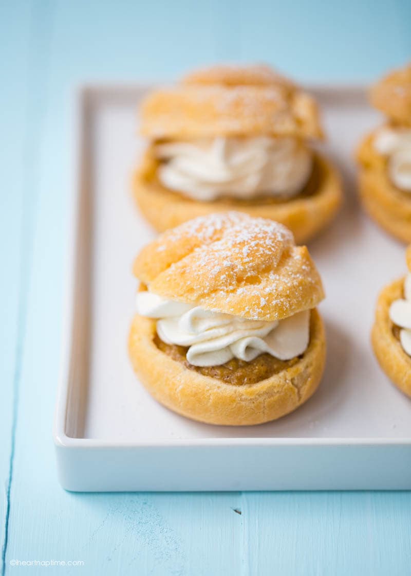 Pumpkin pie cream puffs on white tray.