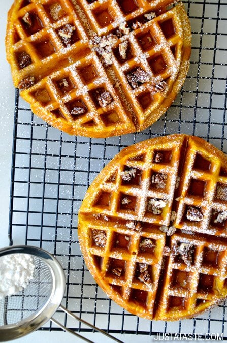 Pumpkin waffles a cooling rack with icing sugar on top.