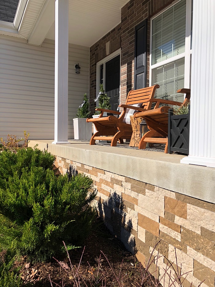 Airstone foundation with porch and wooden chairs.