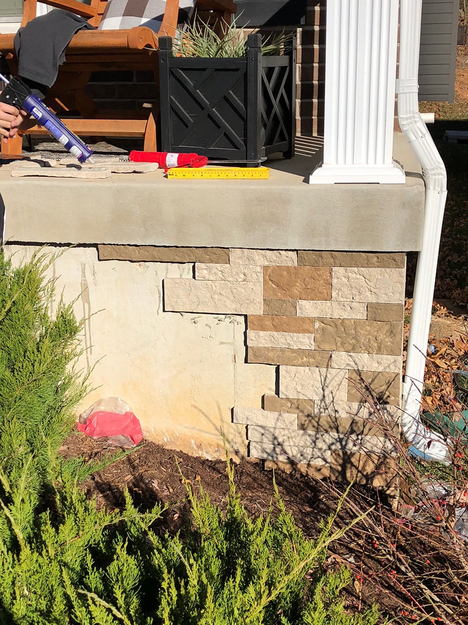 Gluing the brick pieces in place on foundation.