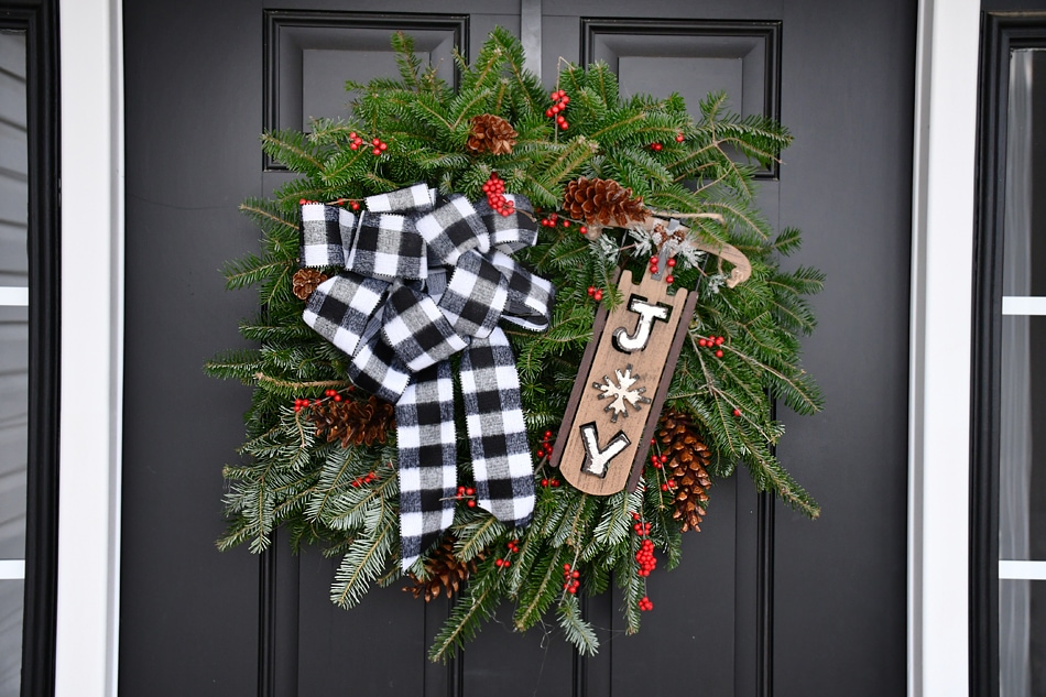 Christmas buffalo check wreath hanging on the door.