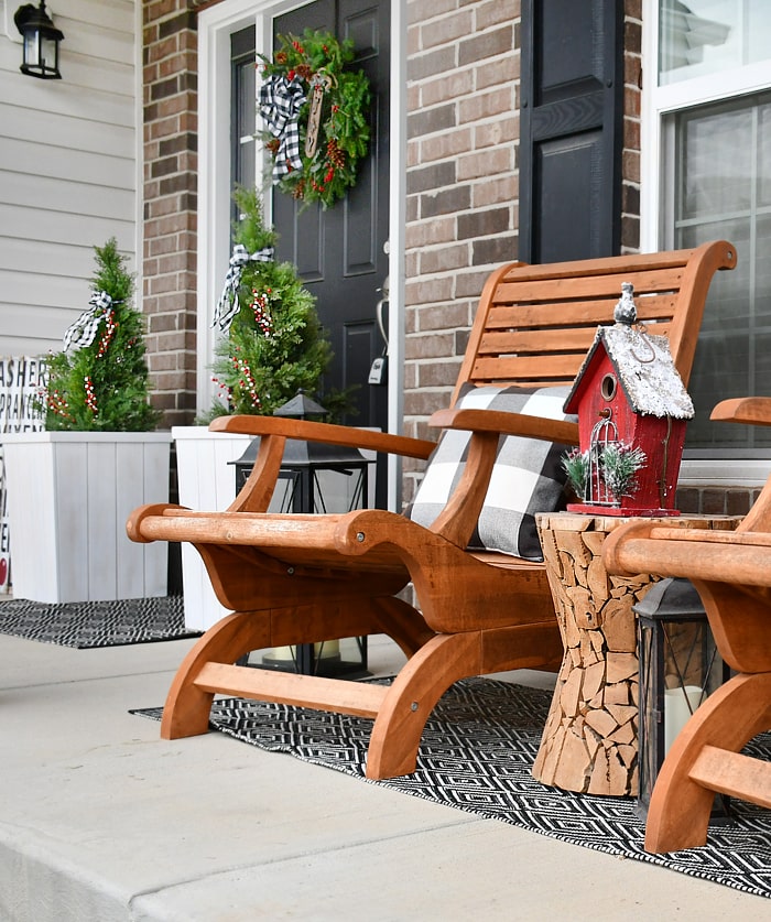 A red birdhouse on the porch beside the chairs.