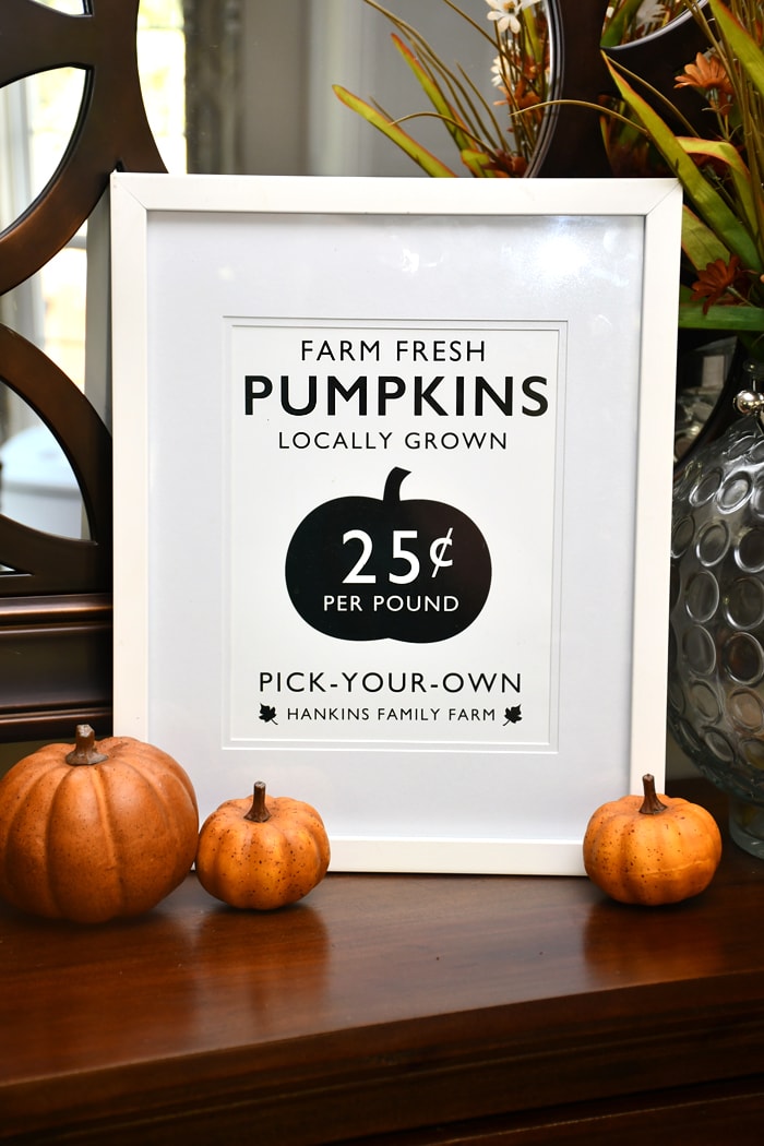 A Farm Fresh Pumpkin printable framed in white sitting on the dresser.