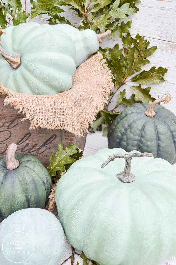 Painted pumpkins in light blues and greys sitting on the porch.