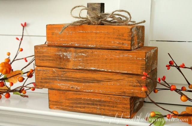 Painted scraps of wood stacked up with berries on branches.